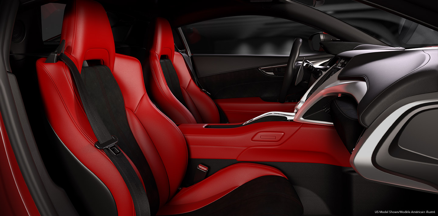 Interior red and black front cabin of an Acura NSX Supercar as seen from the passenger side doorway. Vue de l’habitacle avant rouge et noir d’une supervoiture Acura NSX depuis la portière côté passager.